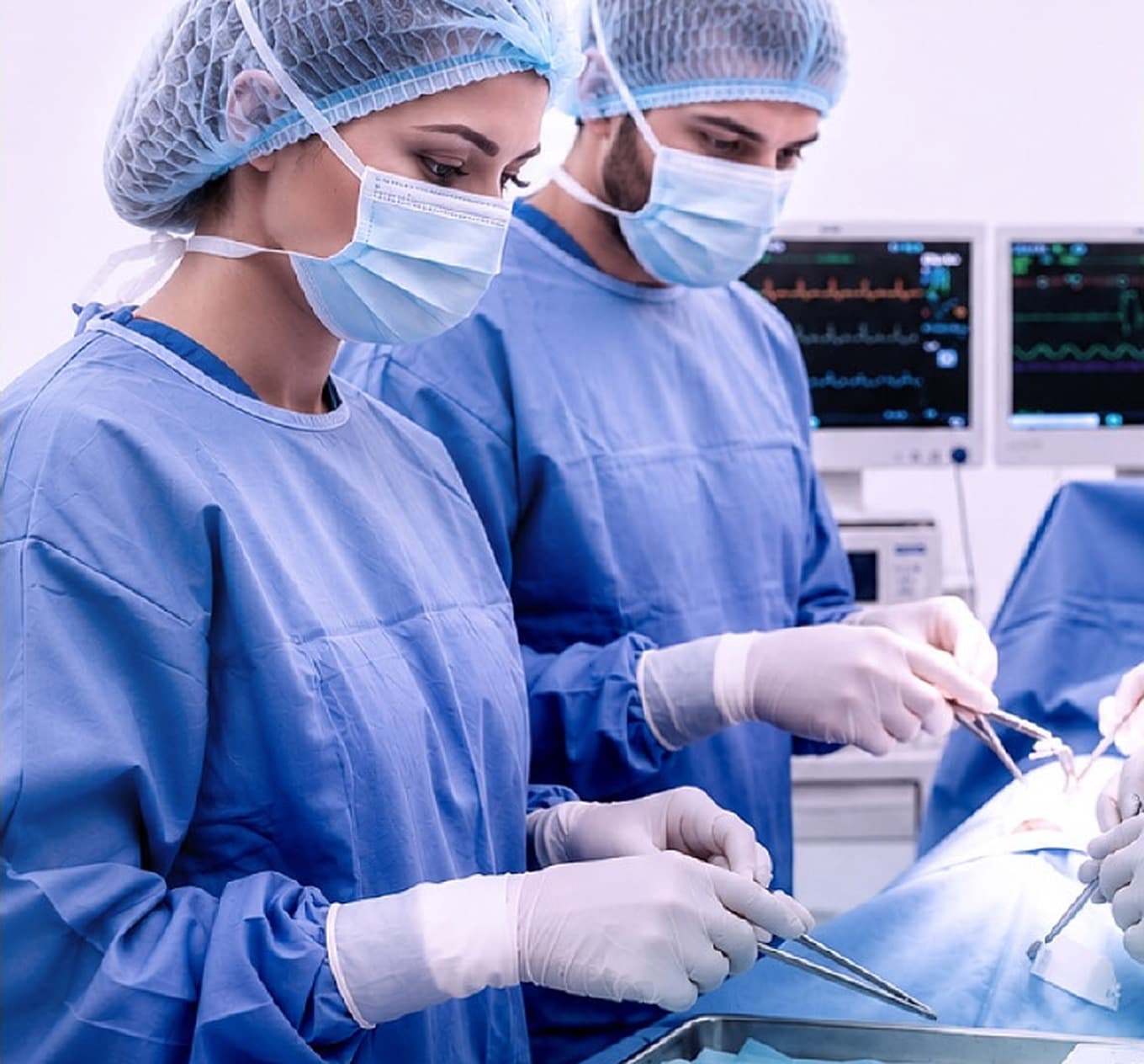 Surgeons in scrubs and masks performing an operation